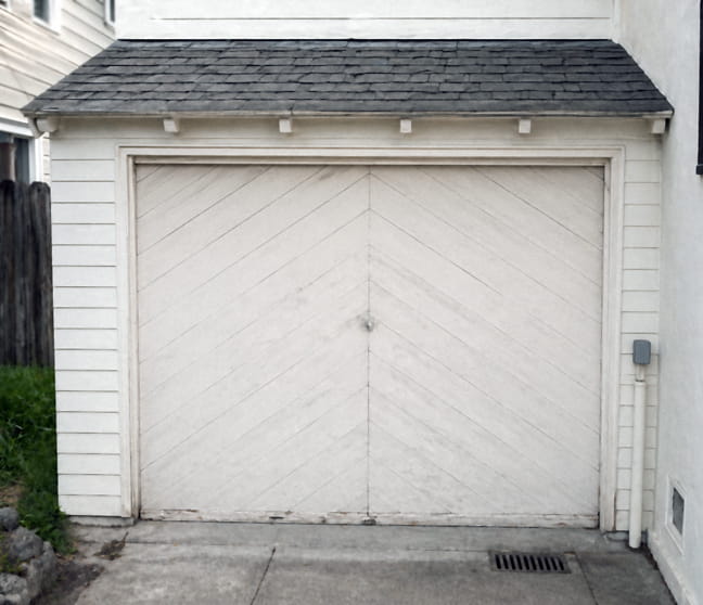 Original single-piece tilt-up wood garage door on a 1940s Walnut Creek home before replacement